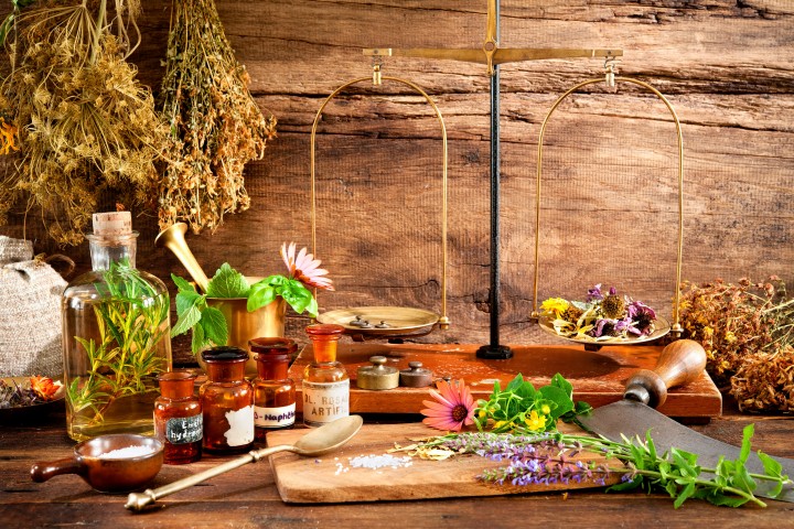 ancient natural medicine herbal vials and scale on wooden background